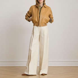 Model wearing Lauren caramel zip-up bomber jacket, styled with wide-leg cream trousers and brown heeled mules.