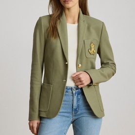 Model wearing Lauren Light Agave blazer jacket with gold crest badge and buttons, styled with white tee and blue jeans