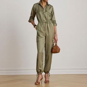 Model wearing Lauren Light Agave utility jumpsuit with elasticated waist, cargo pockets, styled with strappy heels and small tan bag