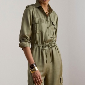 Model wearing Lauren jumpsuit in Light Agave, utility-style with chest pockets and elasticated waist, styled with gold chain necklace and cuff
