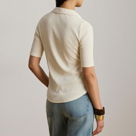 Model wearing Lauren Mascarpone Cream knit polo top, back view, styled with light blue jeans and brown cuff bracelet.