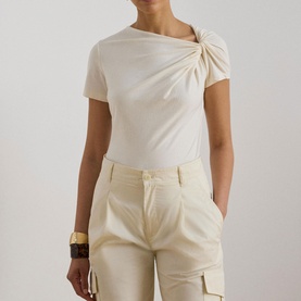 Model wearing Lauren Mascarpone Cream knit top with twisted shoulder detail, styled with cream cargo trousers and wood bangle