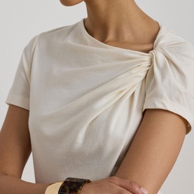Model wearing Lauren Mascarpone Cream top with gathered twist detail at neckline, styled with a gold cuff bracelet.