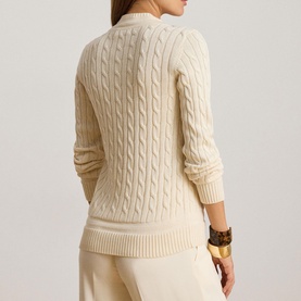 Model wearing Lauren Mascarpone Cream cable-knit sweater, rear view, styled with cream wide-leg trousers and gold cuff bracelet.