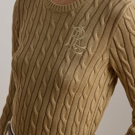 Model wearing Lauren cable-knit jumper in Birch Tan with embroidered RLS logo at chest, close-up detail shot