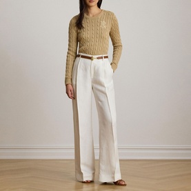 Model wearing Lauren Birch Tan cable-knit jumper, styled with wide-leg white trousers and a tan belt.