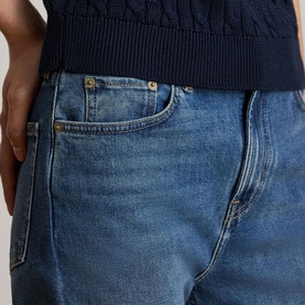 Model wearing Lauren navy knitwear, styled with mid-wash blue denim jeans visible below hem.