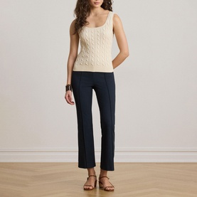 Model wearing Lauren Mascarpone Cream cable-knit tank top, styled with navy straight-leg trousers and tan strappy sandals