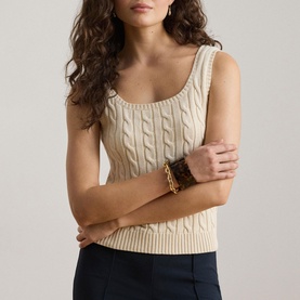 Model wearing Lauren Mascarpone Cream cable-knit sleeveless top with scoop neck, styled with navy trousers and gold bracelet stack