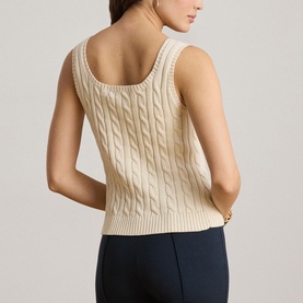 Model wearing Lauren Mascarpone Cream cable-knit sleeveless top, shown from behind, paired with navy trousers