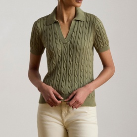 Model wearing Lauren light agave cable-knit polo top with short sleeves and open collar, styled with cream trousers