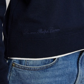 Model wearing Lauren navy knitwear with contrast cream ribbed hem, styled with light wash denim jeans. Script logo embroidery at chest.