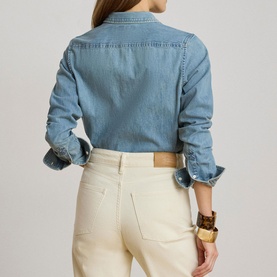Model wearing Lauren shirt in Alicia Wash denim, back view, styled with cream trousers and gold bangles
