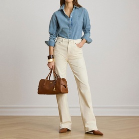 Model wearing Lauren shirt in Alicia Wash denim, styled with cream wide-leg jeans; model carrying tan leather holdall bag