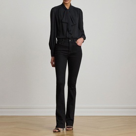 Model wearing Lauren black tie-neck blouse with long sleeves, styled with black flared jeans and strappy heeled sandals