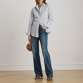 Model wearing Lauren blue multi striped cotton shirt, styled with mid-wash flared jeans and brown leather bag.