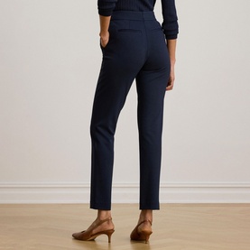 Model wearing Lauren navy tailored trousers, rear view, styled with a navy top and brown heeled mules