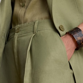 Model wearing Lauren Light Agave linen trousers with matching blazer and shirt, styled with a brown tortoiseshell cuff bracelet.