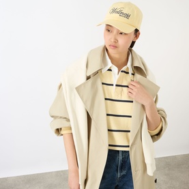 Model with Sporty and Rich Avenue Logo Baseball Cap in Almond Dark Navy, curved visor, embroidered logo, styled with beige trench coat and striped