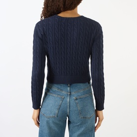 Model wearing Sporty and Rich Dark Navy cable-knit cropped sweater, back view, styled with light blue jeans.