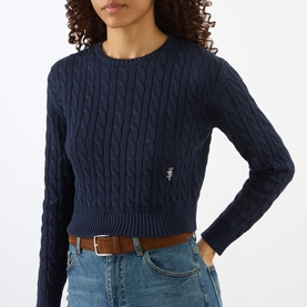 Model wearing Sporty and Rich Dark Navy cable-knit cropped jumper with crew neck, styled with blue jeans and tan belt.