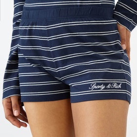 Model wearing Sporty and Rich dark navy and white stripe shorts with elasticated waist and embroidered logo hem detail.
