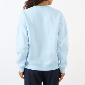 Model wearing Sporty and Rich ciel blue crew neck sweatshirt, back view, styled with navy trousers.