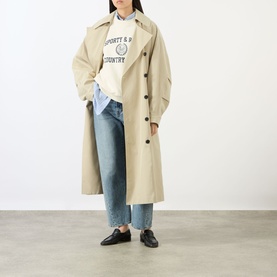 Model wearing Sporty and Rich Ecru cotton sweatshirt, styled with beige trench coat, light-wash wide-leg jeans and black loafers.