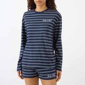 Model wearing Sporty and Rich dark navy and white striped long-sleeve T-shirt with logo script, styled with matching shorts