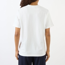 Model wearing Sporty and Rich white T-shirt, rear view, styled with navy trousers.