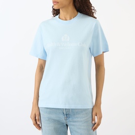 Model wearing Sporty and Rich Ciel blue crew neck T-shirt with tonal logo print, styled with light wash jeans