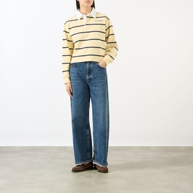 Model wearing Sporty and Rich almond navy striped cotton polo top with wide-leg blue jeans and brown loafers.