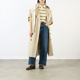 Model wearing Sporty and Rich Almond Navy cotton top, styled with stone trench coat, wide-leg dark blue jeans and brown loafers