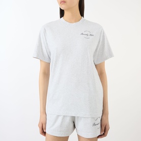 Model wearing Sporty and Rich Heather Grey cotton T-shirt with small chest logo, styled with matching grey shorts.