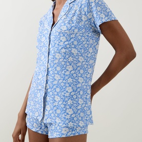 Model wearing Stripe & Stare La Jardin Bleu pyjamas in blue floral print modal short-sleeve shirt and shorts set
