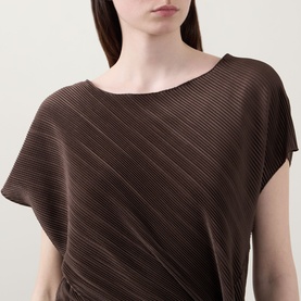 Model wearing Vince Diagonal Pleated Twist Dress in brown, showing slash neckline, cap sleeves and diagonal pleated structure.
