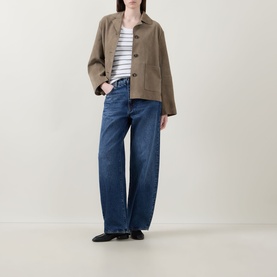 Model wearing Vince Stripe Ribbed Tank Top in white, styled with a khaki jacket and wide-leg blue jeans.