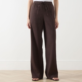 Model wearing Vince Drawstring Summer Trousers in brown, wide-leg linen-blend with drawstring waist, paired with strappy heeled sandals.