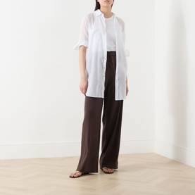 Model wearing Vince Drawstring Summer Trousers in brown wide-leg silhouette, styled with a white longline shirt and flat sandals.