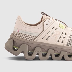 On Running trainer in Sand Desert, featuring chunky taupe wave sole with lime green accents and tonal mesh upper, close-up detail shot.