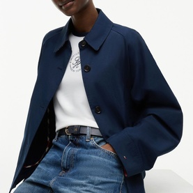 Model wearing Tommy Hilfiger Dark Night Navy cropped jacket, styled with white graphic tee, blue jeans and black belt