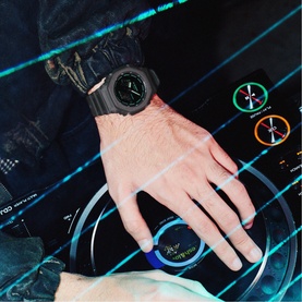 Model with Casio grey digital sport watch on wrist, worn against a dark tech-inspired background with glowing digital graphics