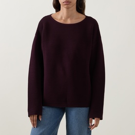 Model wearing Elena Miro must knit jumper with wide sleeves and boat neckline, styled with blue jeans