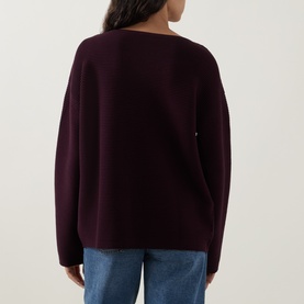 Model wearing Elena Miro must knit jumper, back view, with relaxed fit and long sleeves, styled with blue jeans.