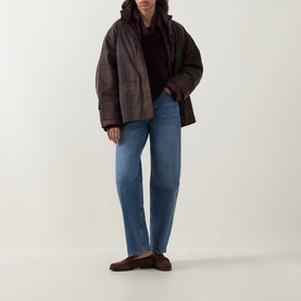 Model wearing Elena Miro must knitwear hoodie, styled with brown plaid puffer jacket and blue straight-leg jeans