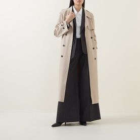 Model wearing HIGH Shimmy Layered Pinstripe Blazer in grey, styled with a white shirt, long beige coat and wide-leg black trousers.