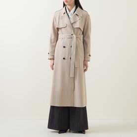 Model wearing HIGH Smuggler Trench Coat in beige, double-breasted longline design with belt, epaulettes and notch lapel, styled with black wide-leg