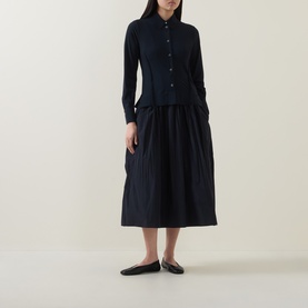 Model wearing HIGH Habit Shirt Dress in navy, midi length with crinkled skirt, raised shirt hem, button front, styled with black flat shoes