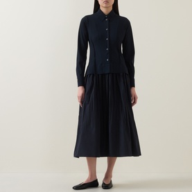 Model wearing HIGH Habit Shirt Dress in navy, midi length with raised shirt hem, crinkled fabric, and button front, styled with black flat shoes.