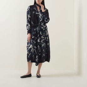 Model wearing HIGH Skive Printed Tie-Front Dress in blue abstract print, midi length, long sleeves, styled with black flat shoes.